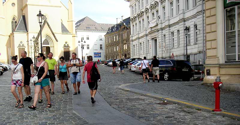 schmaler befahrbarer Streifen auf einem gepflasterten Platz vor einer Kirche